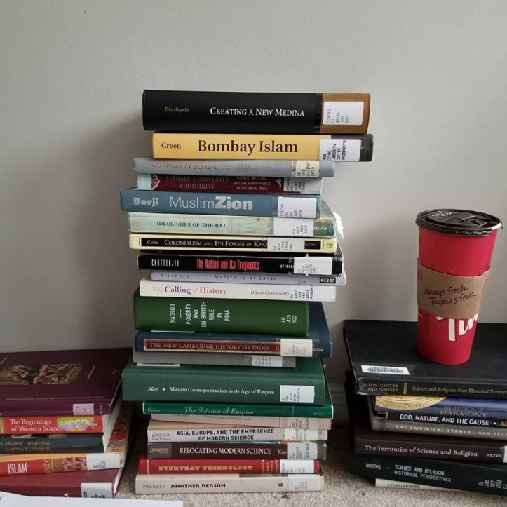 A stack of books about history of science, India, and religion.